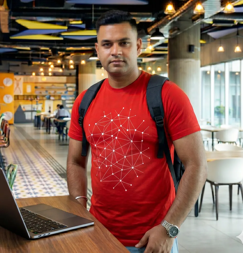 Man wearing a red atom science graphic T-shirt in an office